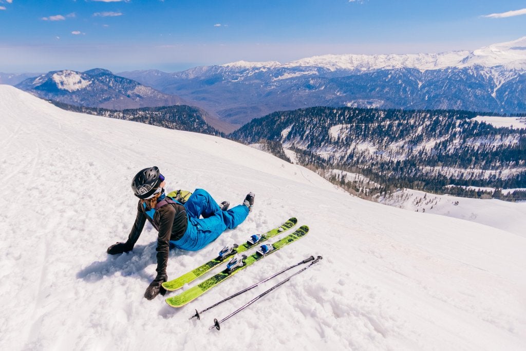 Inspired female skier is relaxing and enjoying a picturesque