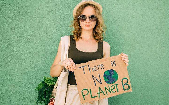 A girl holding a sign saying "There is no planet B"