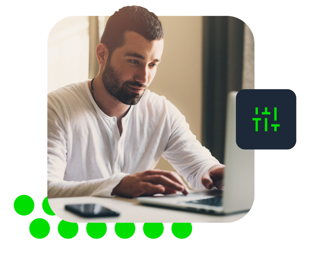 Photo of person with blurred face typing on laptop, smartphone nearby and code icon overlay