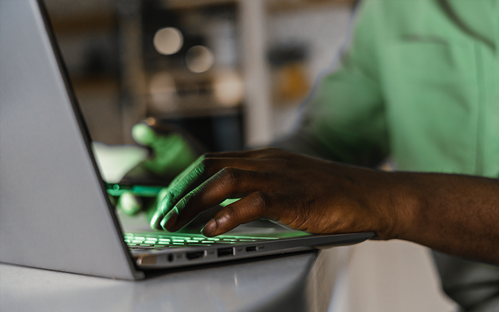 Hands typing on a laptop representing how artificial intelligence can streamline your business processes and enhance productivity.