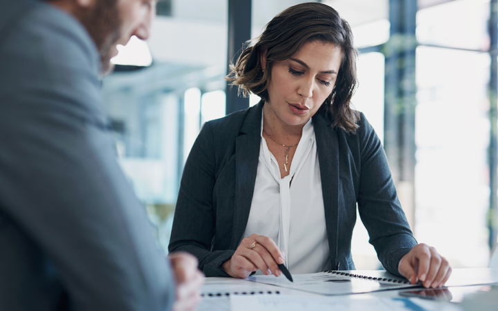 A woman reviewing a business travel programs with a colleague 