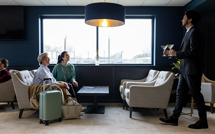 Business travellers seated in a hotel lounge being served