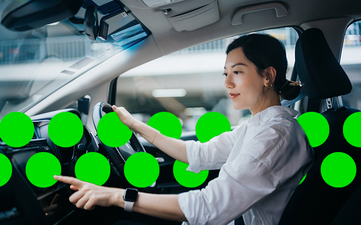 Businesswoman seated in a rental car, highlighting the role of ancillary charges in corporate travel
