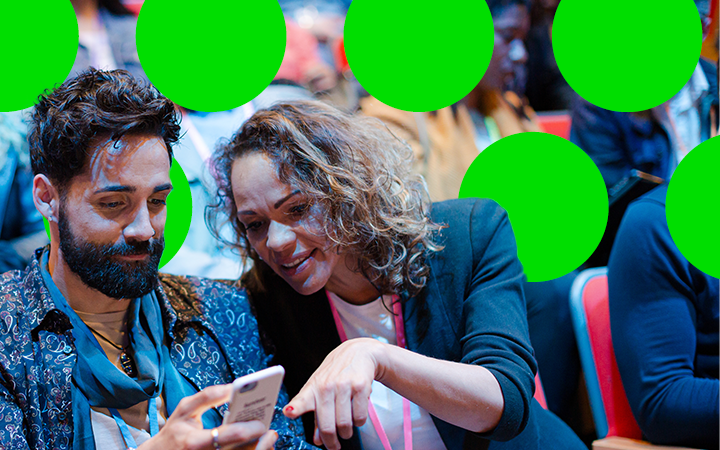 couple at an event looking at a phone