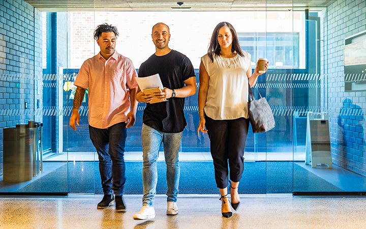 Three people walking through sliding doors 
