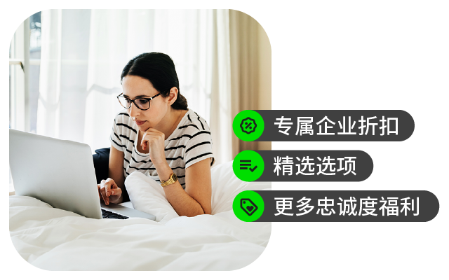 年轻女性坐在床上专注地使用笔记本电脑。
