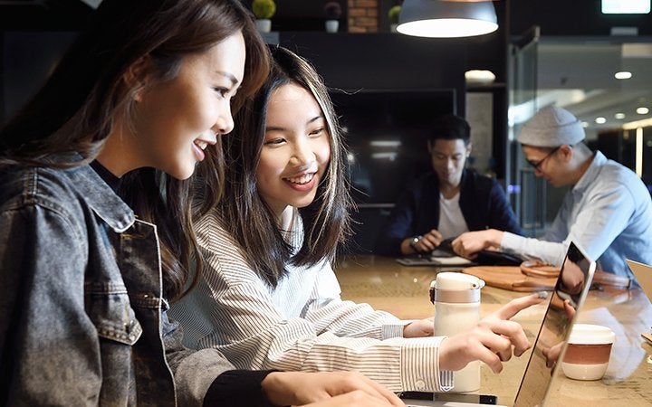 2 women looking at the computer screen and discussing 