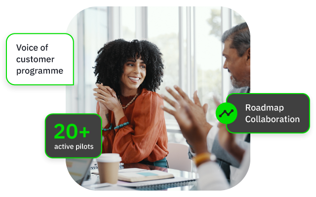 Two colleagues discussing with green labels about customer program pilots, roadmap collaboration