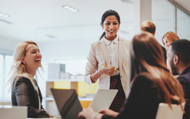 A diverse group of professionals engaged in a lively discussion in a modern office.