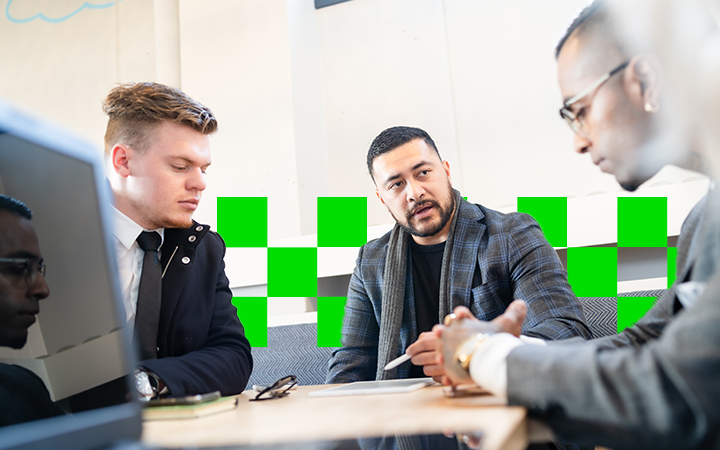 Three men around a table having a meeting