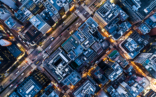 Night aerial photograph of city grid with glowing streets and buildings