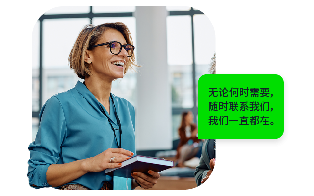 一位微笑的女性，穿着蓝色衬衫，手持笔记本，背景有多人。