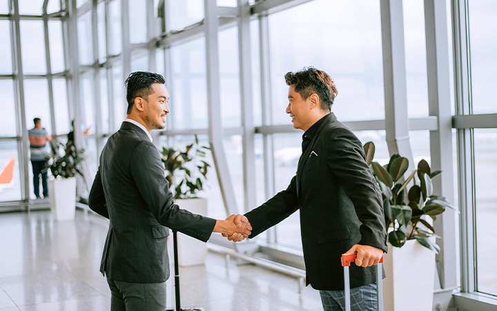 two men shaking hands in an airport