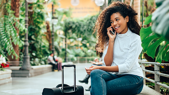 woman-with-suitcase-on-phone