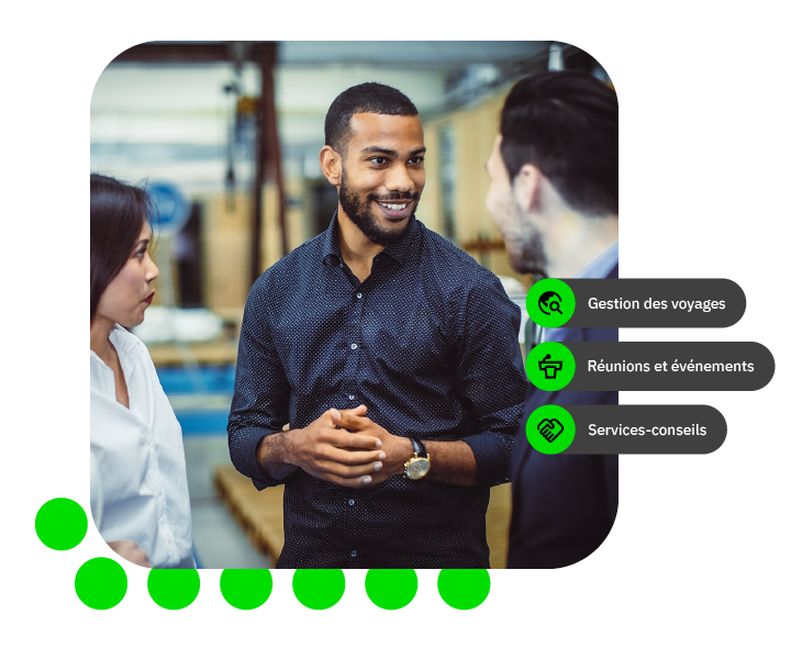 Trois personnes discutent dans un environnement de travail, souriantes et engagées.