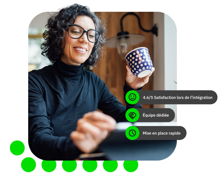 Femme souriante avec des lunettes tenant une tasse dans un décor moderne.