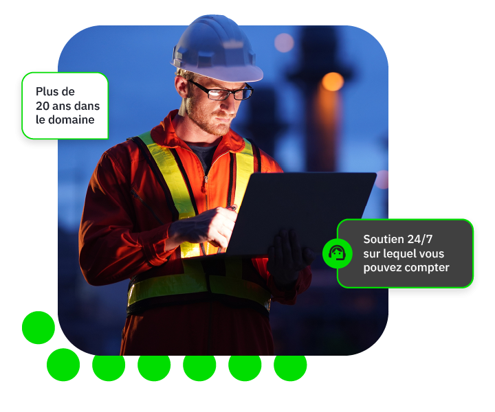 Travailleur en tenue de sécurité utilisant un ordinateur portable dans un environnement industriel.