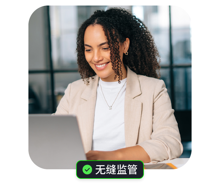 一位微笑的女性在办公室中使用笔记本电脑。