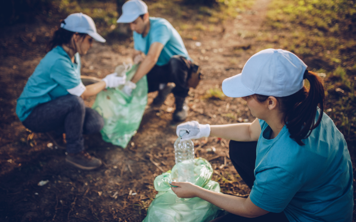 People doing community work picking up rubbish highlighting effective strategies for hosting responsible events that create a positive impact.