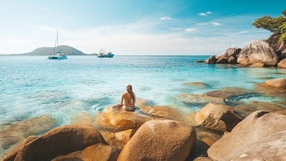 Picture of a person sitting on rocks looking out to the ocean 