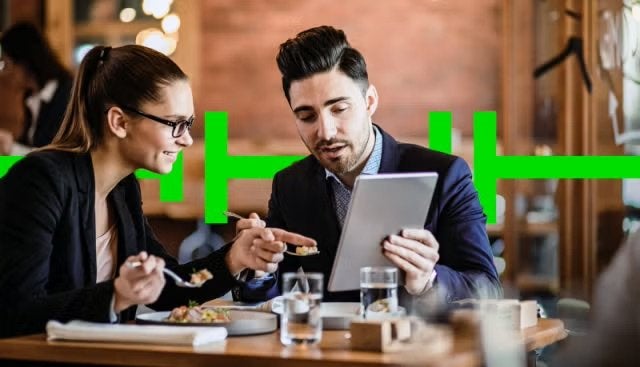 Co-workers enjoying a meal while working representing how businesses that use FCM’s popular Breakfast Plus accommodation program will enjoy another free ‘value-add’ when they visit any one of the 3000+ partner hotels worldwide.